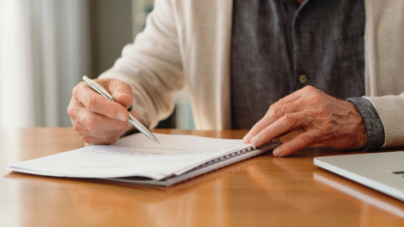 Una donna seduta a un tavolo con carta e penna