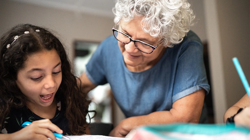 Seniorin unterstützt ein Kind.