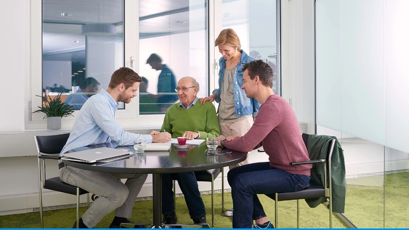 Familie am Tisch in Beratungssituation