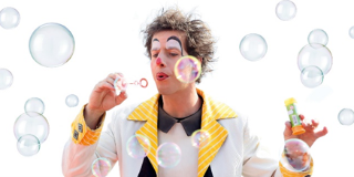 Ein Clown bläst Luftblasen in die Luft 