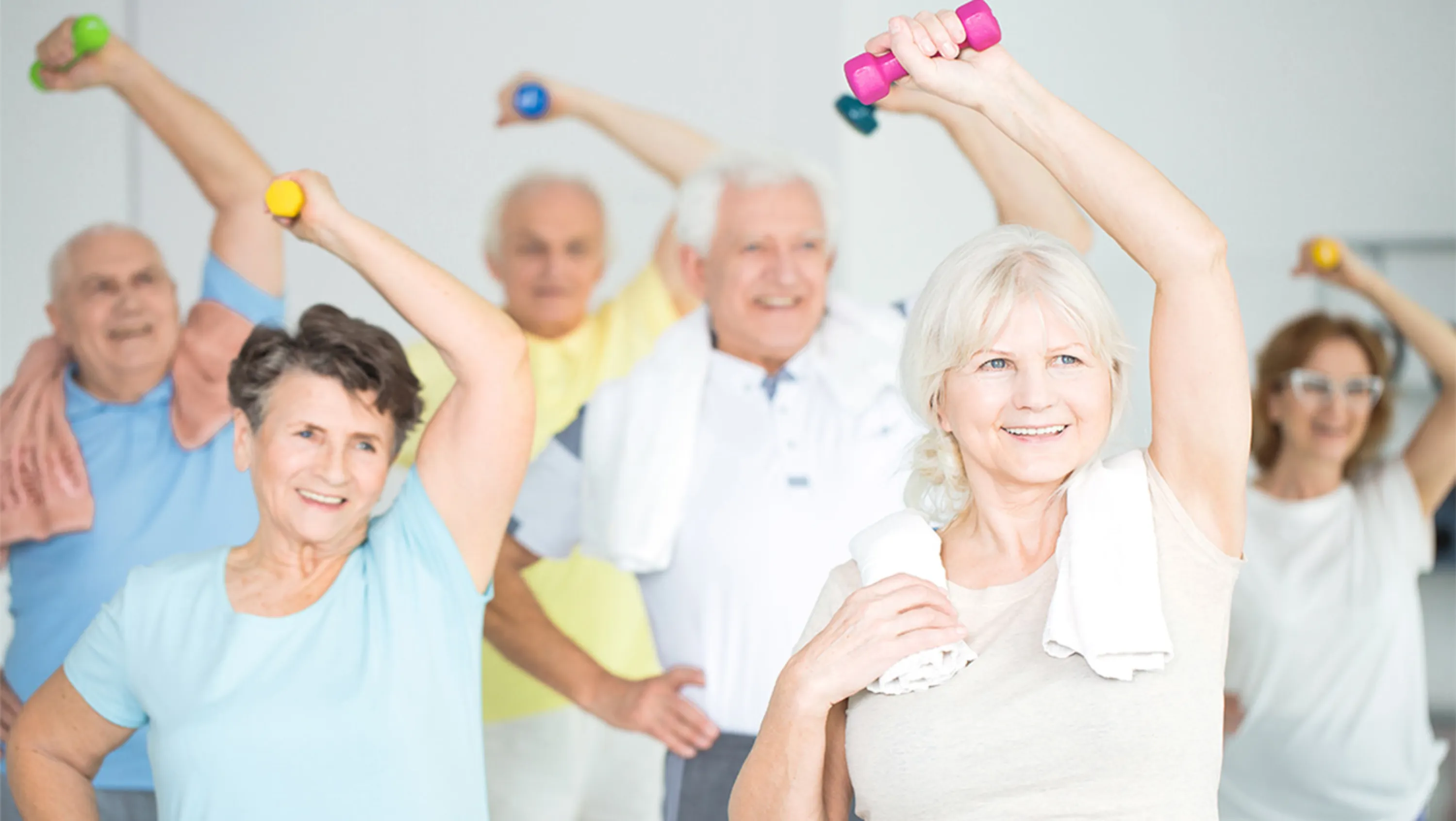 Gruppe Menschen turnen in der Halle mit Hanteln