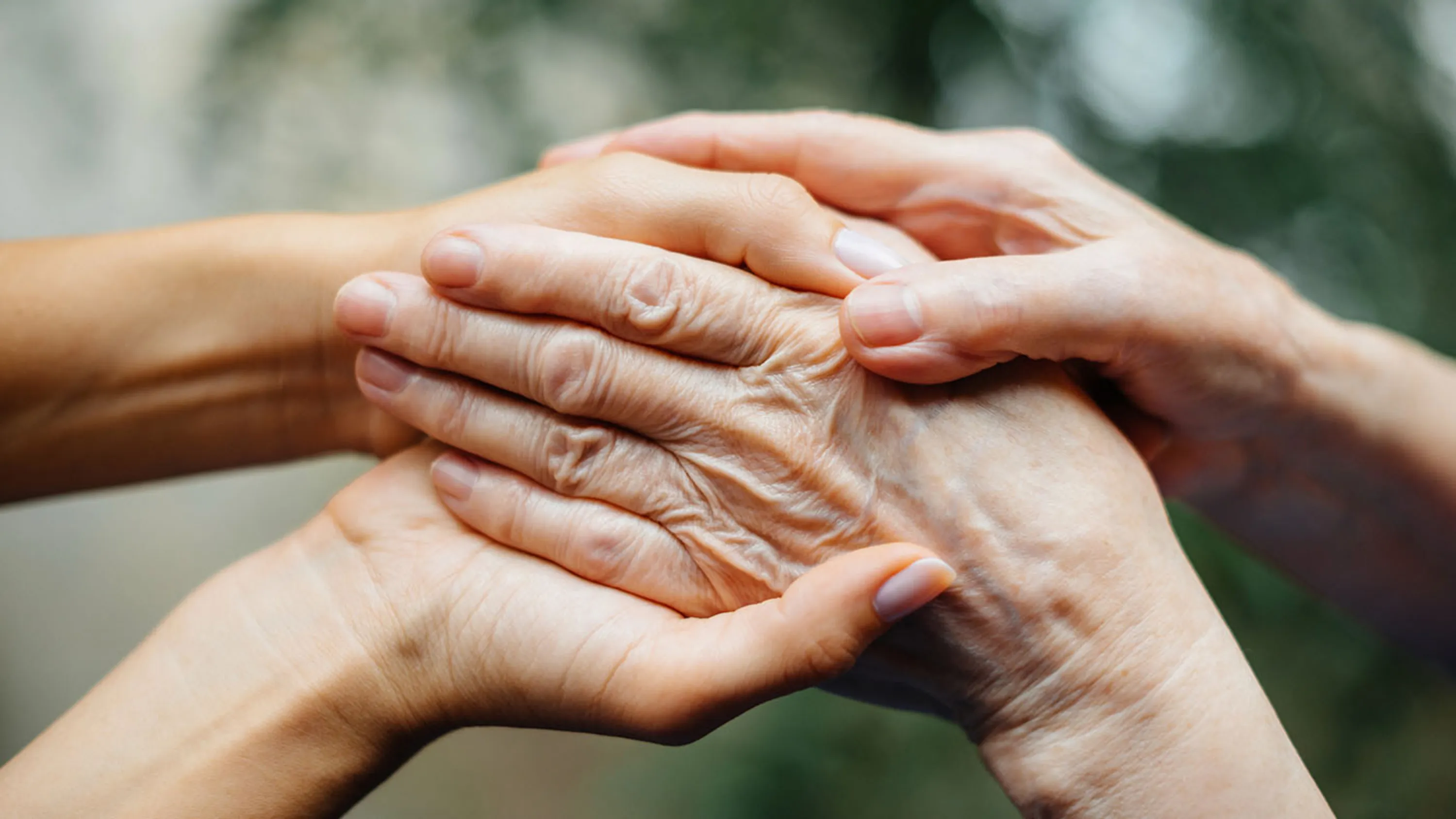 Junge und alte Hände halten sich