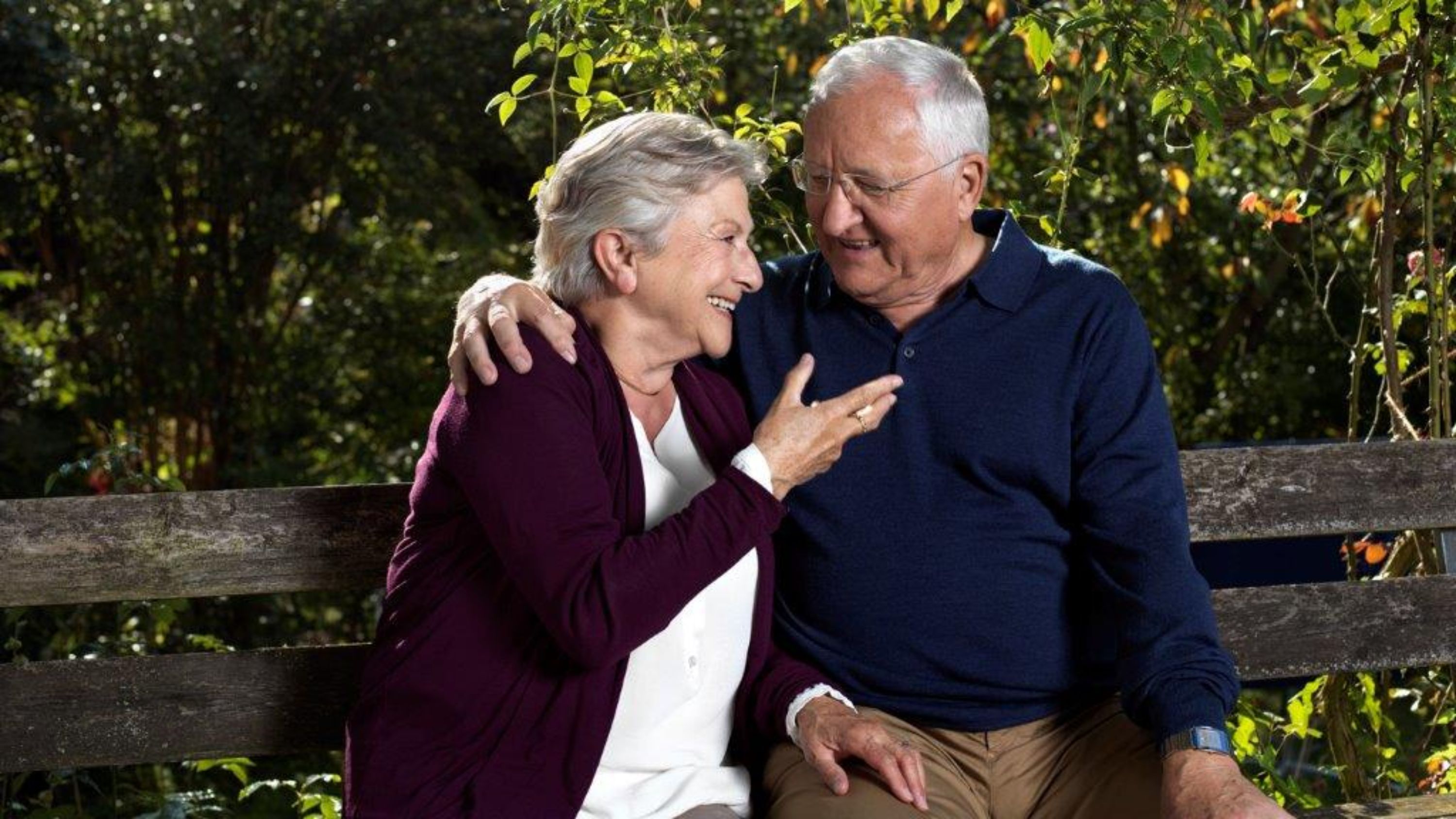 Due persone anziane si sono sedute su una panchina.