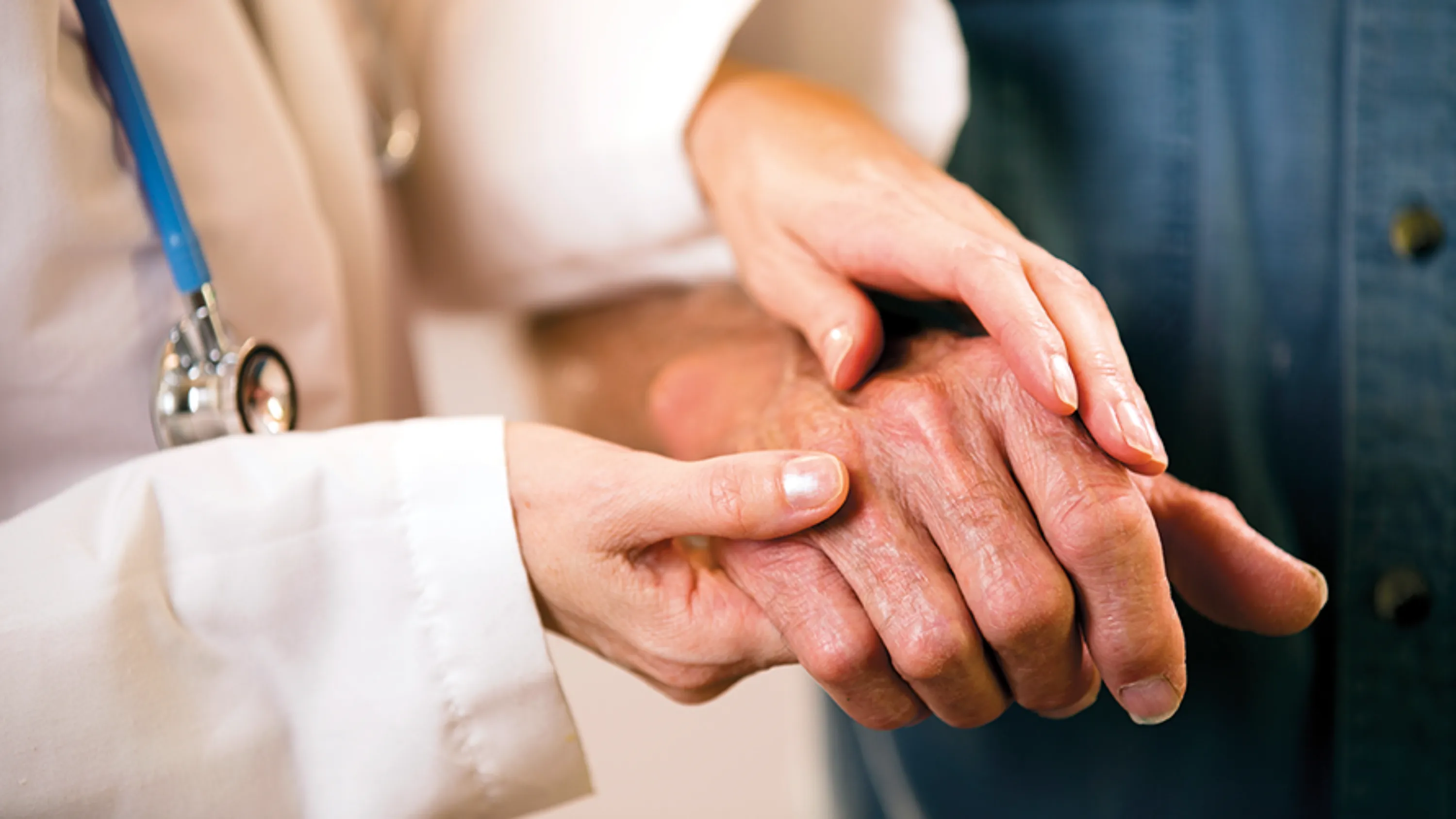 Arzt hält Hände von Patient