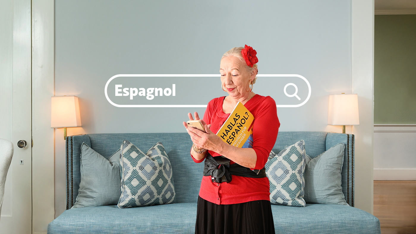 Une femme âgée cherche un cours d'espagnol via son smartphone.